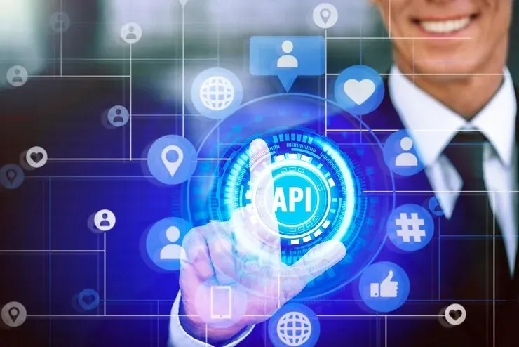 Businessman touching a glowing API button surrounded by network and social icons