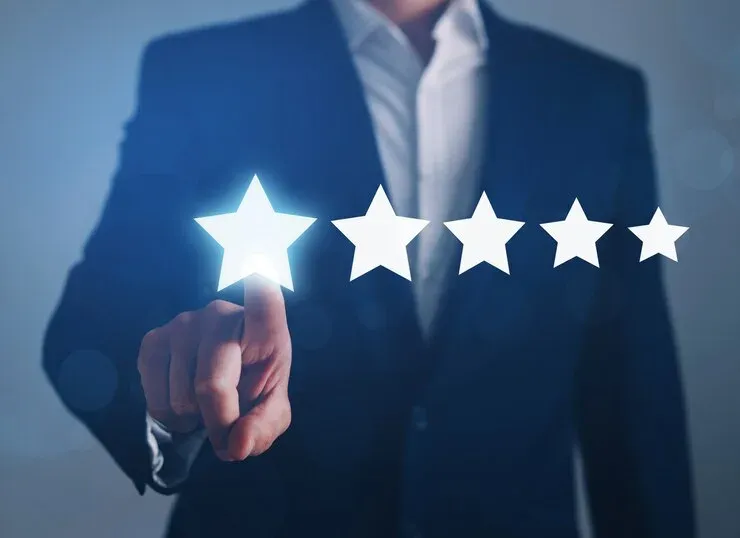 Businessman touching the first of five glowing rating stars