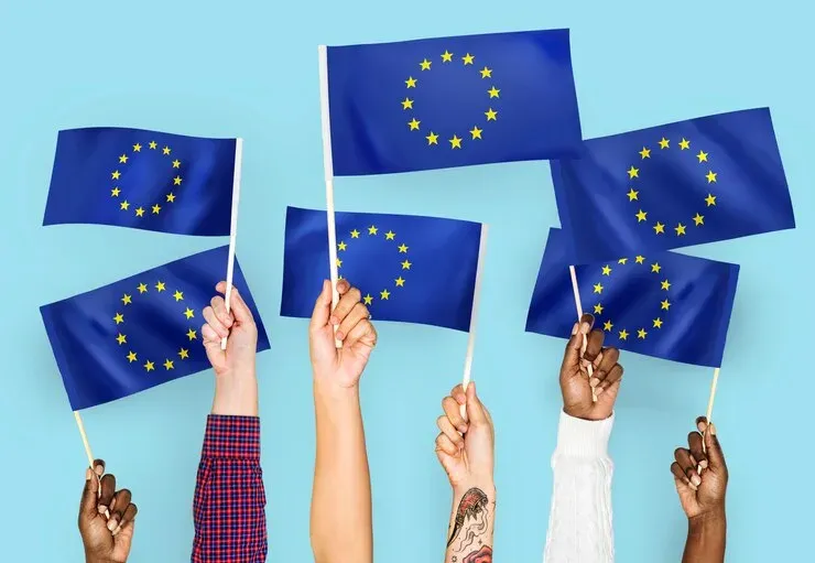 Several hands waving European Union flags