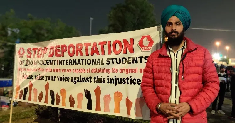Lovepreet Singh beside a protest banner reading stop deportation of innocent international students
