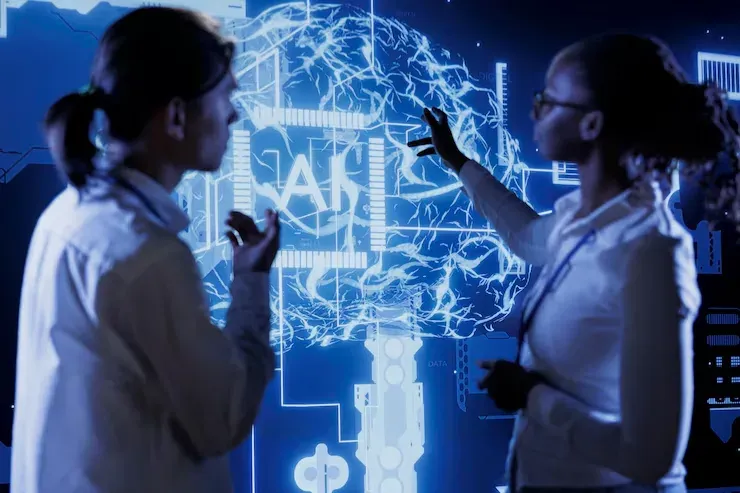 Two women looking at a glowing AI brain display on a large screen