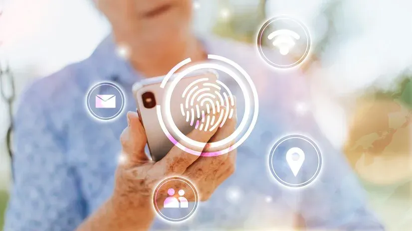 Older person holding a phone with a fingerprint and digital identity icons